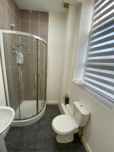 y baño con ducha, aseo y lavamanos. en Midland apartments- Open plan, en Leicester