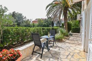 a patio with two chairs and a table at Seagull Pool Apartments & Studios in Novalja