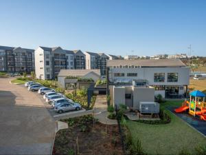 an aerial view of a apartment complex with a parking lot at Ballito Village Luxury Apartments by DropInn in Ballito