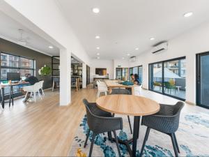 an office with tables and chairs and a living room at Ballito Village Luxury Apartments by DropInn in Ballito