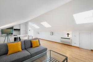 salon z szarą kanapą i żółtymi poduszkami w obiekcie RELSTAY - Arco della Pace - Sunny Loft w Mediolanie