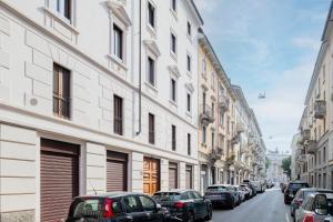 ulica miejska z zaparkowanymi samochodami i budynkami w obiekcie RELSTAY - Arco della Pace - Sunny Loft w Mediolanie