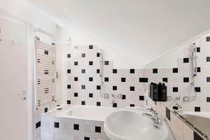 biała łazienka z umywalką i wanną w obiekcie RELSTAY - Arco della Pace - Sunny Loft w Mediolanie +20 zdjęć