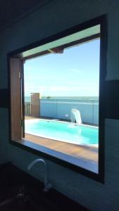 um espelho de casa de banho com vista para uma piscina em Casa de Praia Recanto do Atlântico em Nova Viçosa