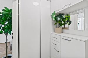 a white bathroom with plants and a mirror at Stylish Flat, next to Handelskai in Vienna