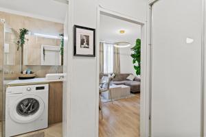a kitchen and living room with a washing machine at Stylish Flat, next to Handelskai in Vienna