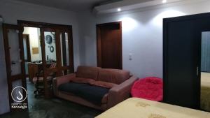 ein Wohnzimmer mit einem Sofa und einem Tisch in der Unterkunft Recanto do Sossego in Santa Cruz do Sul