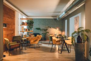 ein Esszimmer mit Tischen, Stühlen und Pflanzen in der Unterkunft Boutique Hotel Villa Alberta in Nago-Torbole + 105 Fotos
