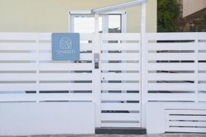 uma cerca branca com um sinal. em Shanti Rooms & Apartments em Bacoli