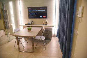 une table et des chaises dans une pièce avec écran d'ordinateur dans l'établissement Shanti Rooms & Apartments, à Bacoli