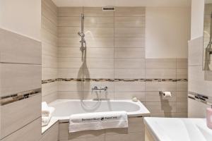 a bathroom with a tub and a sink at Studioapartment am Hafen in Flensburg