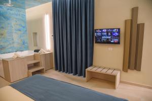 a bathroom with a tv on the wall at Shanti Rooms & Apartments in Bacoli