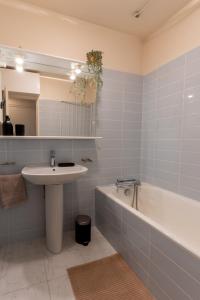 ein Badezimmer mit Waschbecken und Badewanne in der Unterkunft L'Échappée Courbevoie - 2 Chambres in La Défense + 14 Fotos