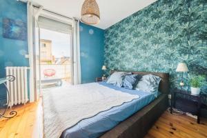 Schlafzimmer mit blauen Wänden, einem Bett und einem Fenster in der Unterkunft SELVES 8 - Maison Jacuzzi in Brive-la-Gaillarde