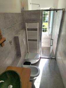 La salle de bains est pourvue de toilettes, d'un lavabo et d'une douche. dans l'établissement Benvenuto, à Venegono Superiore