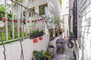 une allée avec des plantes en pot sur un balcon dans l'établissement Comme une maison à Paris, à Paris
