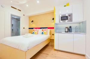 ein kleines Schlafzimmer mit einem Bett und einer Mikrowelle in der Unterkunft Star Street Serviced Apartments by Concept Apartments in London