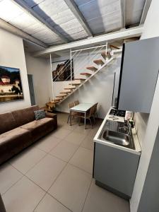 un soggiorno con divano, una cucina e una scala di Residenza il Nespolo - Estella Hotel Collection a Torino
