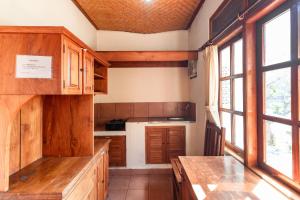 a kitchen with wooden cabinets and a table at Vedanta Villa in Lovina