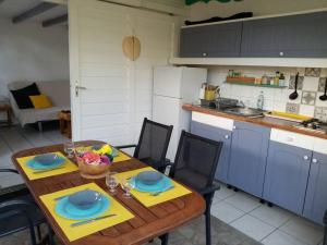 a kitchen with a wooden table with blue cabinets at Bungalow papaye in Sainte-Anne