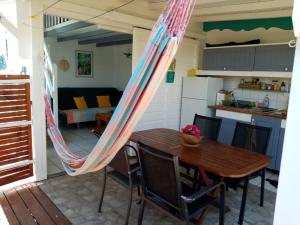 a dining room with a hammock hanging over a table at Bungalow papaye in Sainte-Anne