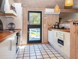 a kitchen with white cabinets and a window at 8 person holiday home in Juelsminde in Sønderby