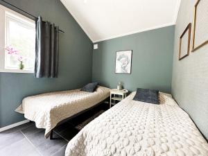 2 camas en una habitación con paredes verdes en Nice holiday home by the lake Vristulve, en Timmersdala