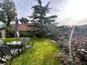 een tuin met een tafel en stoelen en een parasol bij Moonsticks in Norwich