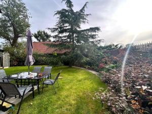 a garden with a table and chairs and an umbrella at Moonsticks in Norwich