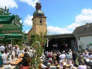 a crowd of people sitting at tables in front of a building at Ferienwohnung Am Odenwaldlimes in Vielbrunn
