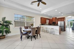a kitchen with a table and chairs in a room at CocoBreeze - Poolside Paradise Mins to Beach! in Naples