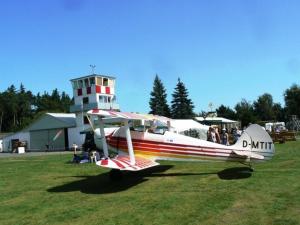 a small plane parked in a field next to a light house at Ferienwohnung Am Odenwaldlimes in Vielbrunn