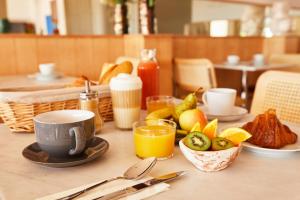 - une table avec une tasse de café et un bol de fruits dans l'établissement Hôtel California, au Lavandou