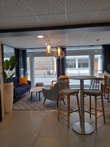 ein Wohnzimmer mit einem Tisch, Stühlen und einem Sofa in der Unterkunft Odalys City Rennes Lorgeril in Rennes