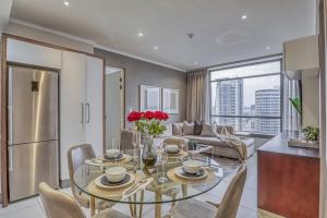 a kitchen and living room with a glass table with roses at Masingita Towers Premium Hotel in Johannesburg