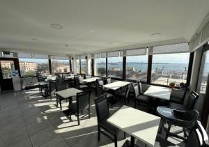 un restaurante con mesas y sillas y vistas al océano en Hanedan Hotel, en Estambul