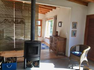 una sala de estar con estufa de leña. en Casa luminosa y confortable rodeada de naturaleza en San Carlos de Bariloche