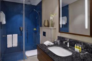 uma casa de banho com um lavatório e uma cabina de duche em vidro. em Marriott Executive Apartments Al Khobar em Al Khobar