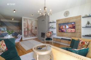 un salon avec un canapé et une télévision dans l'établissement Cherry House Prishtina, à Pristina