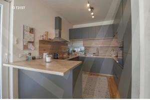 une cuisine avec des placards gris et un comptoir dans l'établissement Cherry House Prishtina, à Pristina