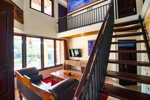 a living room with a staircase leading up to a loft at Vedanta Villa in Lovina