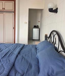 Bett mit blauer Decke in einem Zimmer in der Unterkunft Bo House in Patong Beach