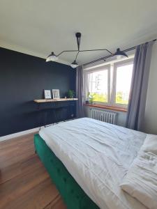 a bedroom with a large bed and a window at Apartamenty Cześć Kraków in Krakow