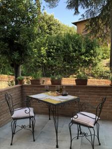 a table and two chairs on a patio at La Tana di Ghino di Tacco in Sinalunga +15 photos