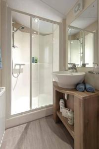 y baño con lavabo y ducha acristalada. en Lagooncombe, modern and cosy (Wi-Fi & Fire Stick) en Millom