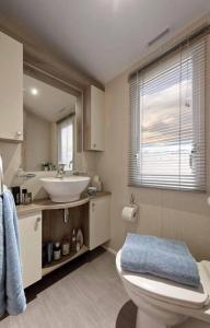 y baño con aseo blanco y lavamanos. en Lagooncombe, modern and cosy (Wi-Fi & Fire Stick) en Millom