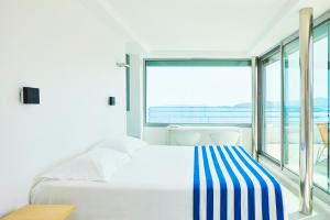 a bedroom with a bed and a view of the ocean at Hôtel California in Le Lavandou
