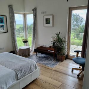 a bedroom with a bed and a piano and a window at Cedarblue in Ballyvoyle Cross Roads