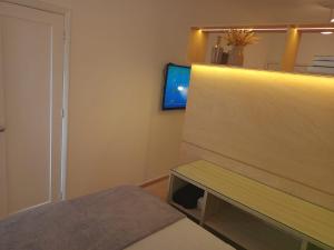 a small room with a bench and a tv at Prime Flat Terê in Teresópolis +9 photos