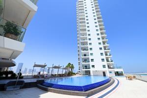 uma piscina em frente a um edifício alto em EliteRetreat - SeaView - Gym & Pool Access - Reem Island em Abu Dhabi
